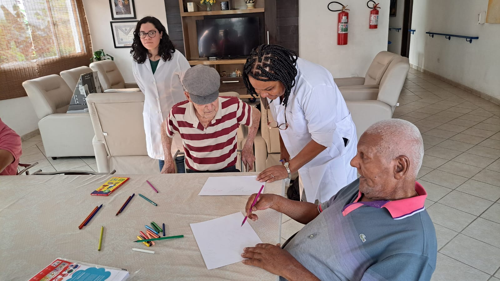 Equipe da CAIFA acompanhando atividade de desenho com residentes