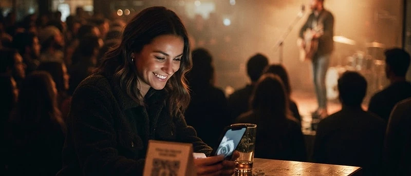 A table tent and one scan — the fan is on your page in seconds.