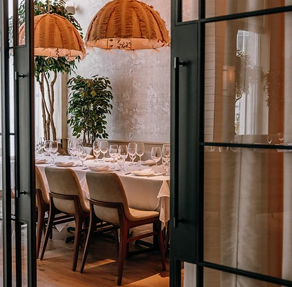 Avra Boston private dining room with wicker pendant lights and a long banquet table