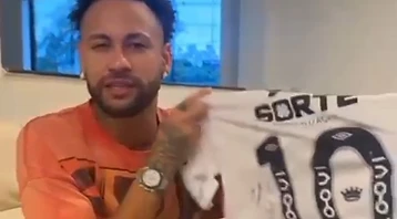 Neymar Jr. segurando camisa de leilão beneficente do Instituto Jordana Bombeiro
