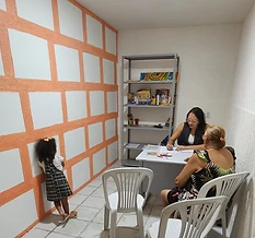 Sala de terapia do Instituto com crianças montando quebra-cabeças no chão