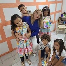 Profissional do Instituto Jordana Bombeiro abraçando criança durante atividade em grupo