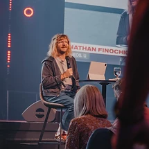 A guest speaker seated on stage sharing at a past Wave Church event