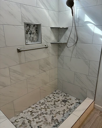 Marble shower with pebble niche and grab bar