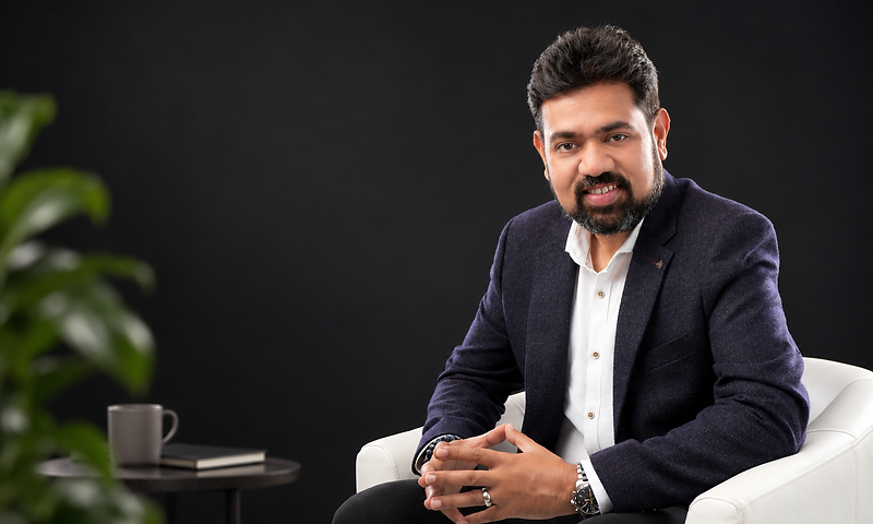 Praveen Bangera, seated in a white armchair