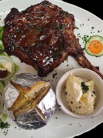 Flame-grilled T-bone with baked potato and salad at Ferreira's