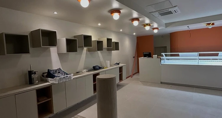 Boulangerie après travaux — intérieur fini avec comptoir et mur d'accent