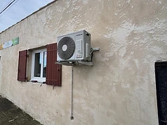 Unité extérieure de climatisation Hitachi sur mur beige
