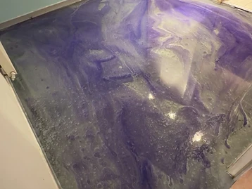 Sol en résine époxy effet marbré, après travaux — finition miroir violette