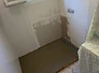 Salle de bain avant travaux — douche démontée, sol et murs bruts