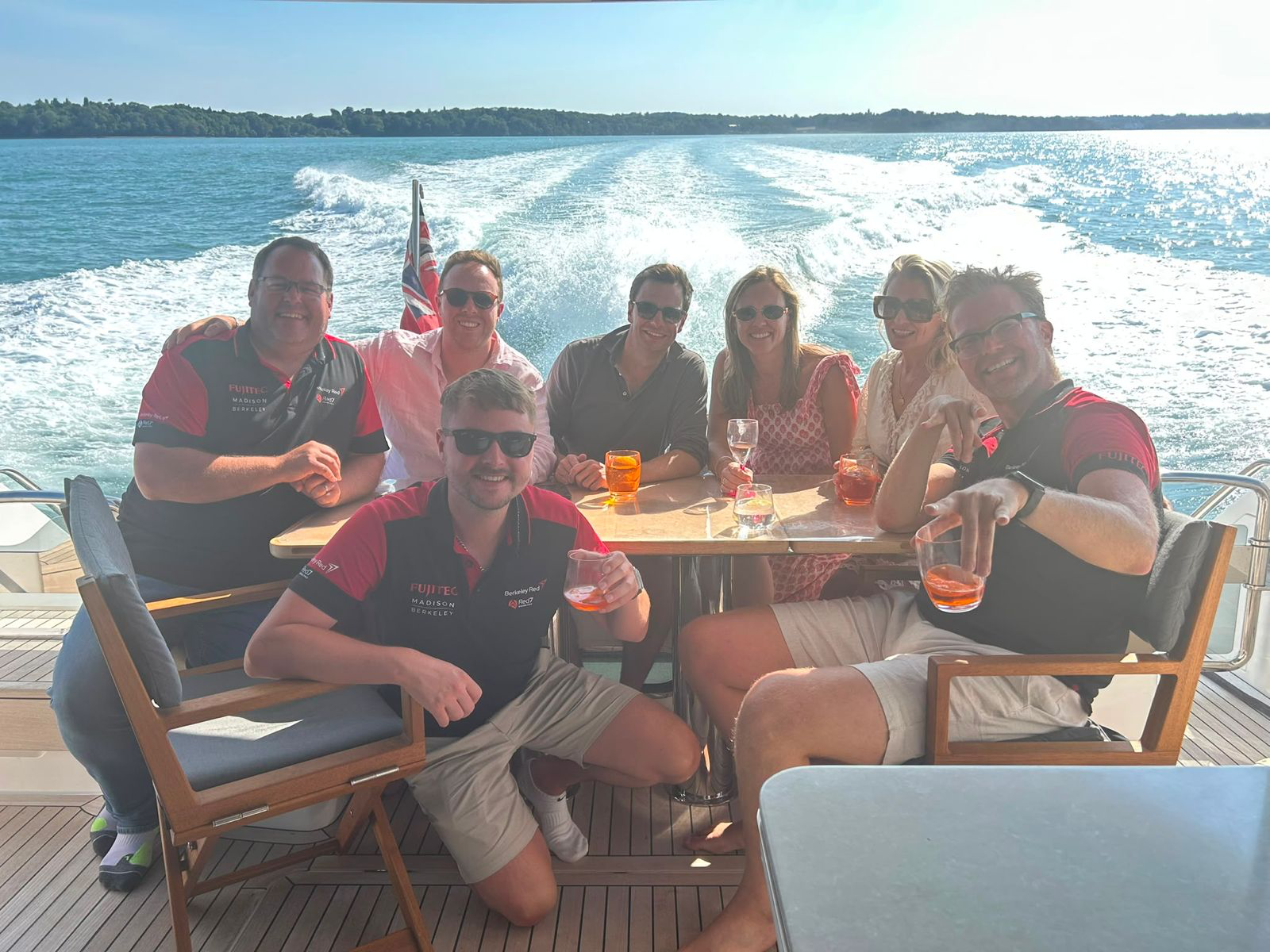 Berkeley Red team and clients toasting on the deck of a boat at sea