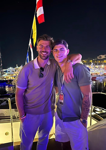 Louis Rees-Zammit with a guest on a yacht in the Monaco marina at night
