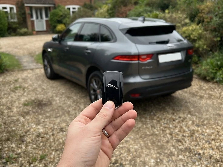 Jaguar smart key held in front of a Jaguar F-Pace