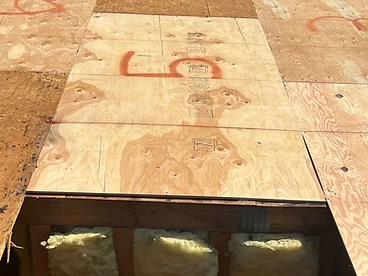 New plywood with red spray paint number 5 next to weathered decking