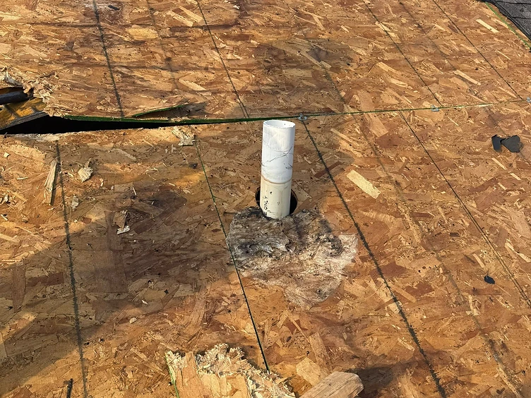 Water-damaged plywood roof deck around a pipe vent