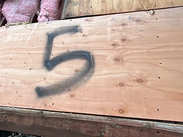 New plywood sheet with black spray paint number 5