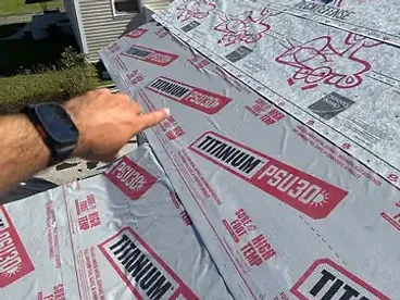 Light gray TITANIUM PSU30 synthetic underlayment installed in overlapping horizontal courses on a residential roof