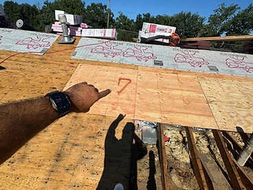 Worker pointing at spray painted number 7 on new plywood