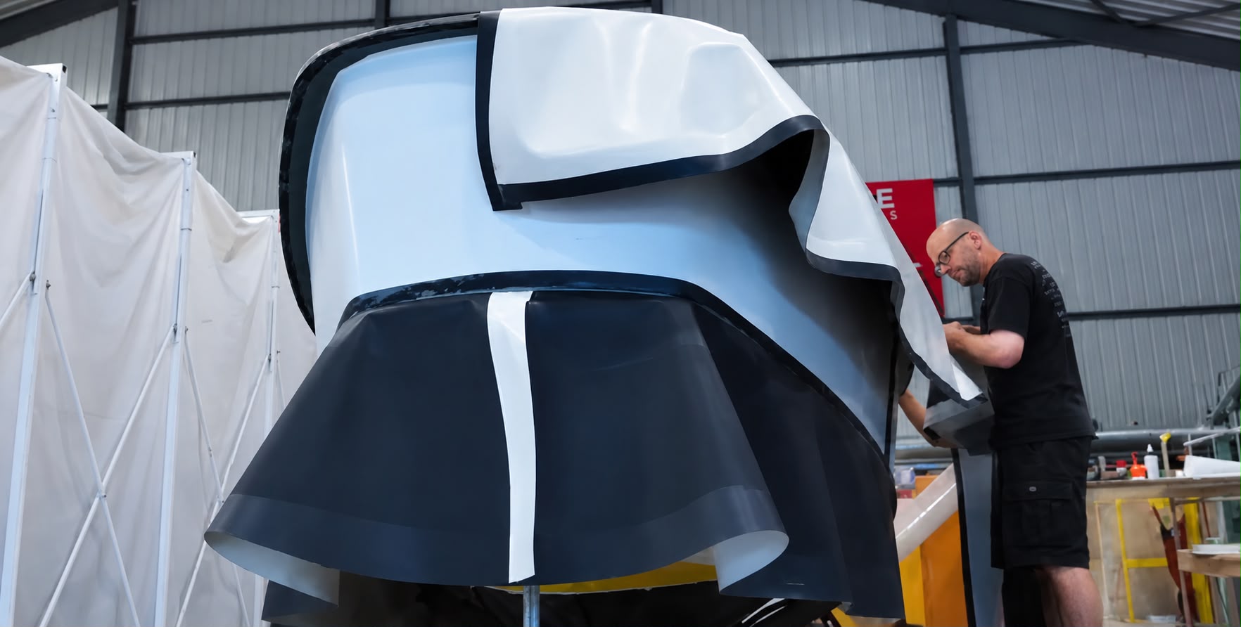 Craftsman fitting a custom tender cover in the workshop