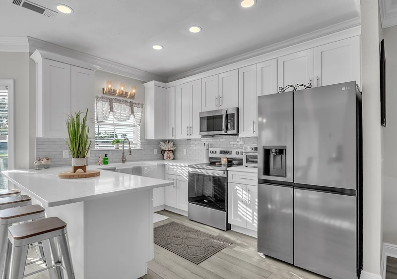 Warm, open-plan coastal home with a remodeled kitchen and living area by Holland’s Construction, Mississippi Gulf Coast