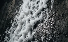 Low pressure soft wash solution being applied to an exterior wall