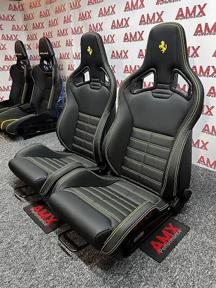 AMX Performance custom carbon fiber bucket seats with yellow contrast stitching displayed in showroom