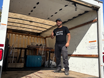 Lamas Moving crew member giving a thumbs up next to a loaded moving truck