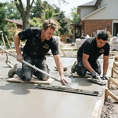 L.O.G Renovation workers finishing a concrete patio pour with a magnesium float