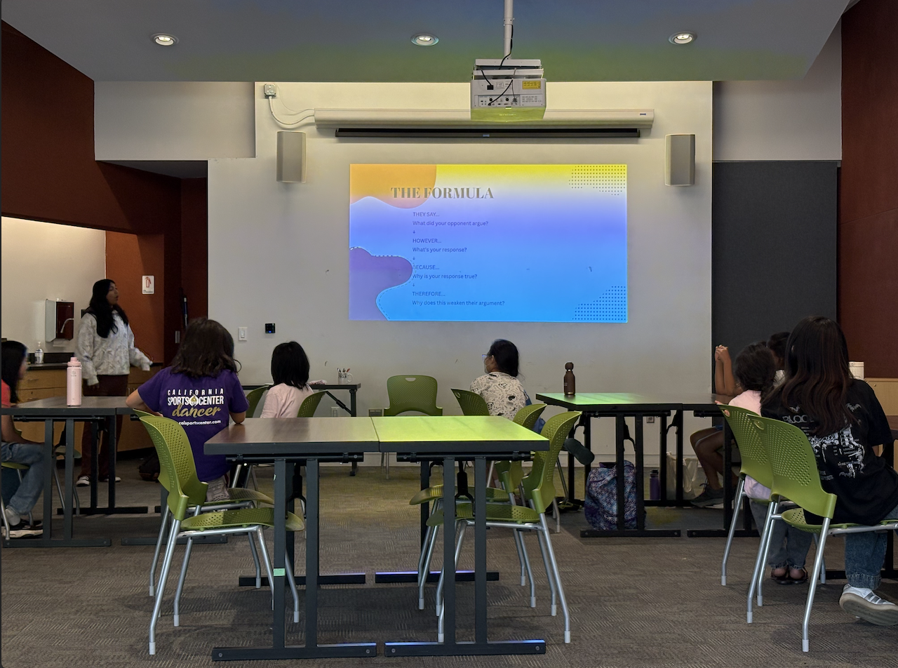 A Take the Mic chapter leader teaching students the debate formula.