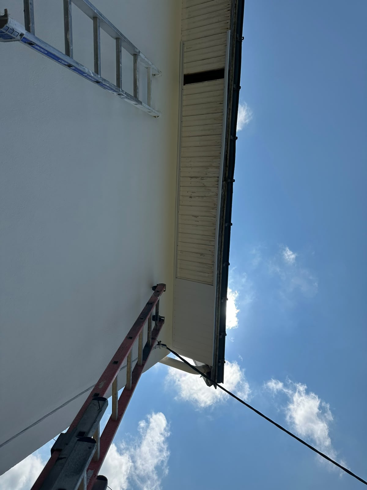 Ancien lambris jauni sous le débord de toit avant remplacement par RP Couverture