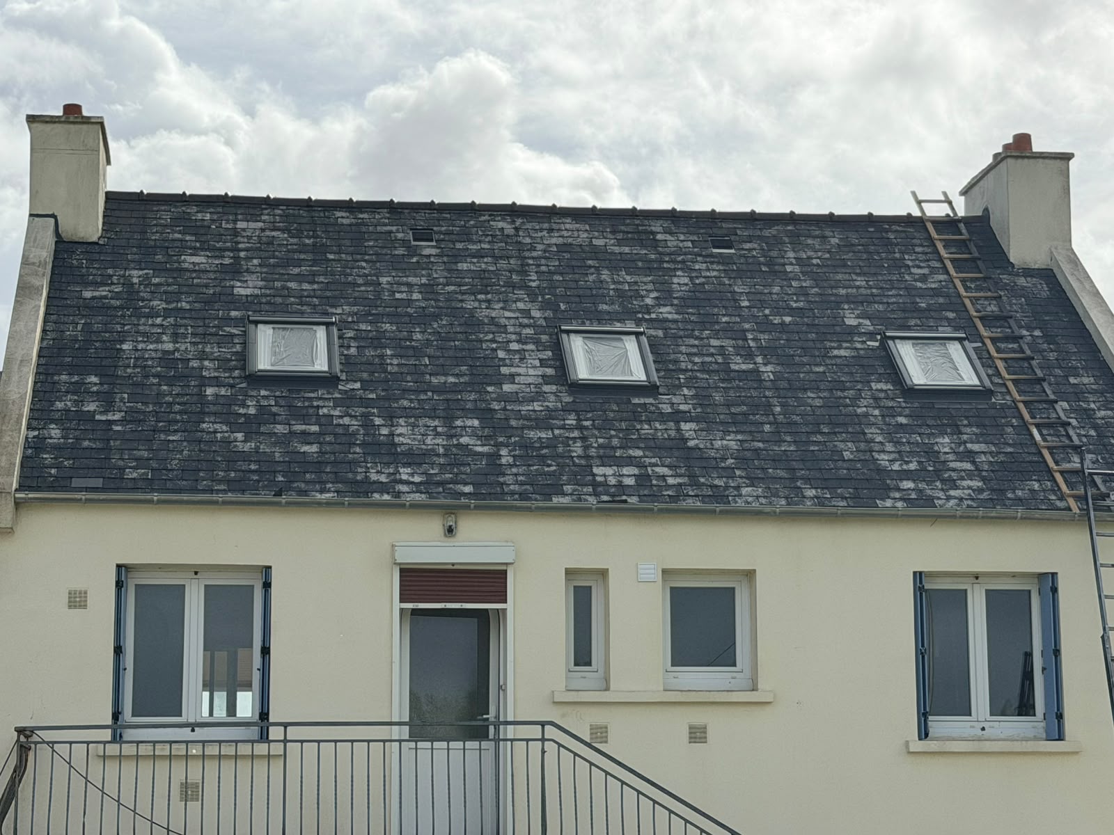 Toiture en ardoises tachée de mousse et de lichens avant démoussage et hydrofuge par RP Couverture