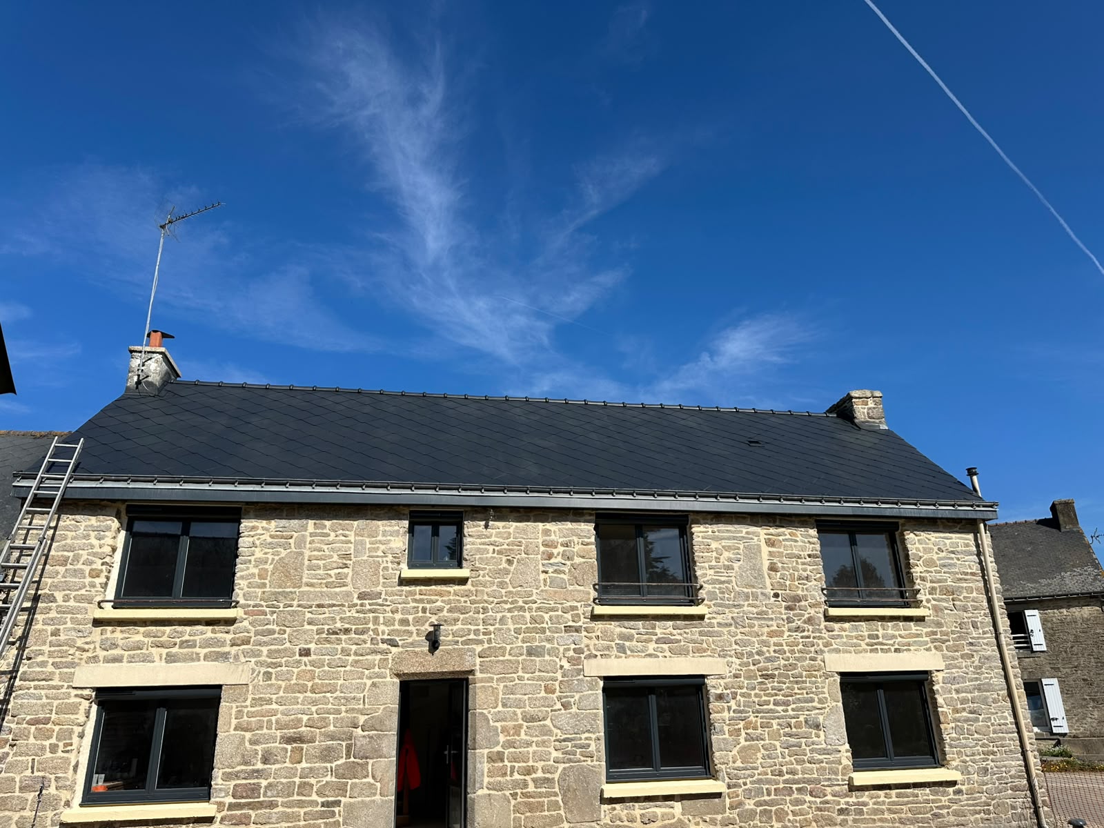 Toiture en ardoises nettoyée et redevenue noire sur une longère en pierre par RP Couverture