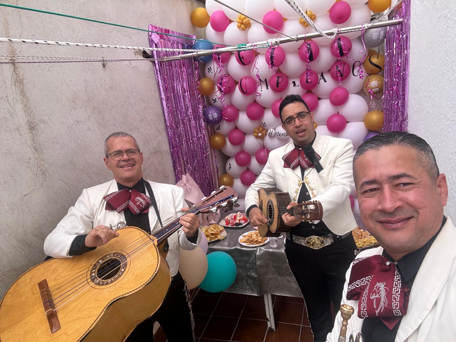 Mariachi Acapulco en cumpleaños en Madrid - trío con trajes blancos y decoración festiva