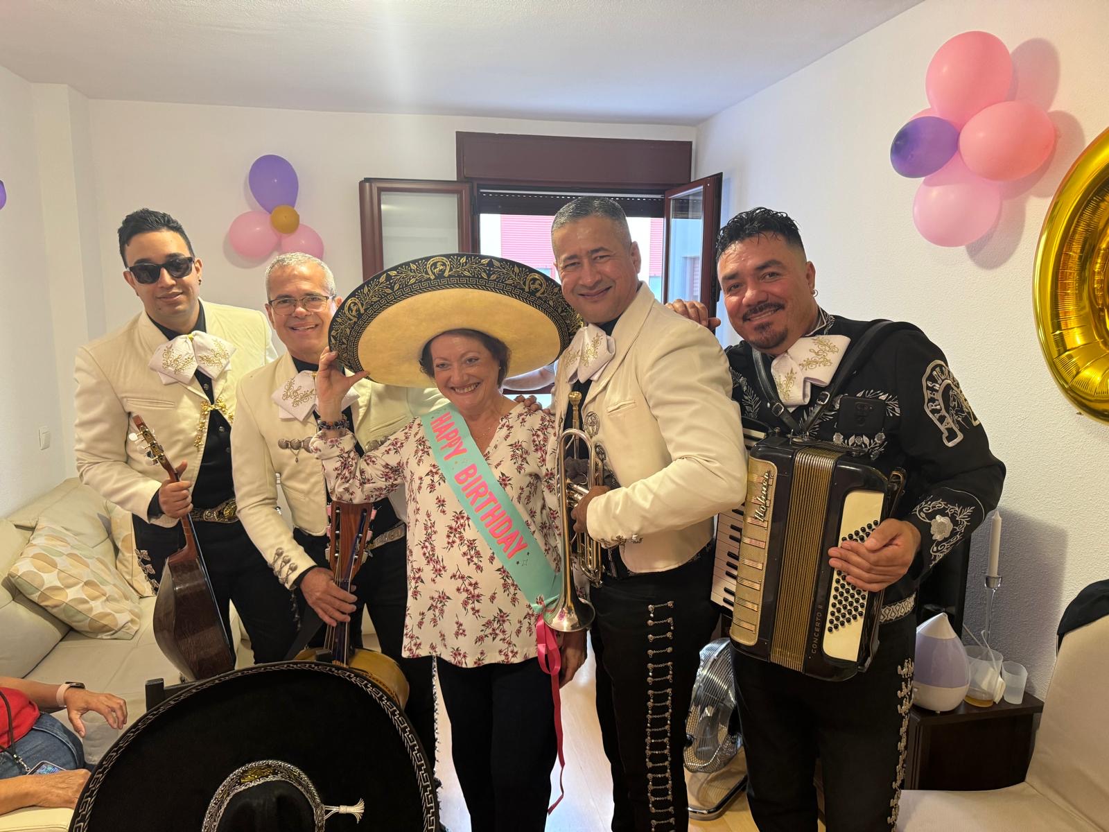 Mariachi Acapulco sorprendiendo a cumpleañera en Madrid con sombrero y sash HAPPY BIRTHDAY