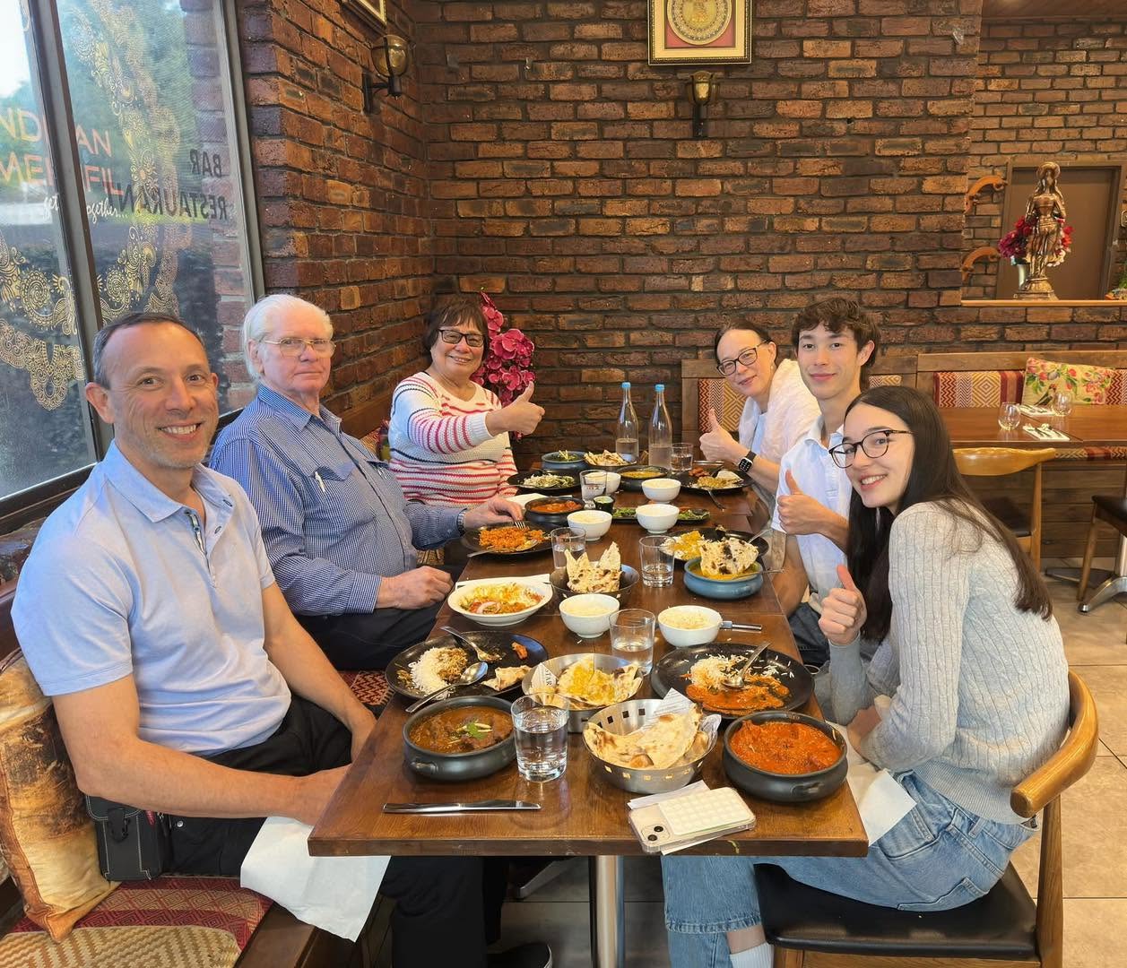 Happy group of diners giving a thumbs up