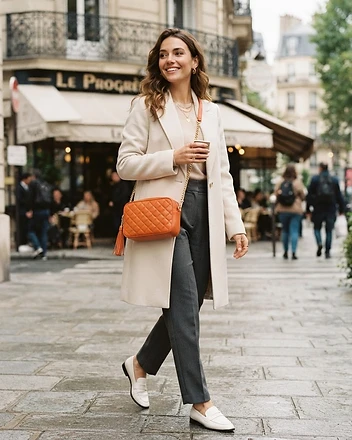 The Solène Tangerine leather crossbody bag worn on model