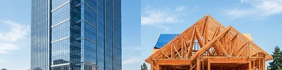 Glass office tower and wood-framed house under construction