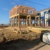 Elevated beach home framing under construction on stilts
