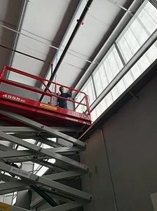 Technician working from a scissor lift in a commercial warehouse