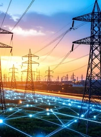 High-voltage power transmission towers at sunset with smart grid energy distribution network