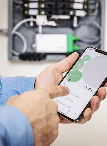 Technician monitoring electrical energy management system on smartphone for battery storage and smart grid applications