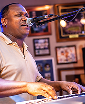 Live music performer singing and playing keyboard at Herby's Sports Bar