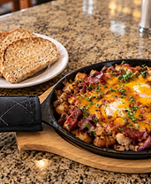 Cowboy skillet with eggs, bacon, potatoes and melted cheddar
