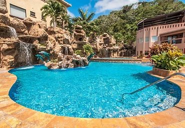 Resort pool with rock waterfall and teal dolphin sculptures