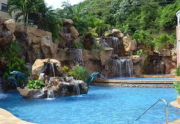 Pool with multi-tier rock waterfall and dolphin statues