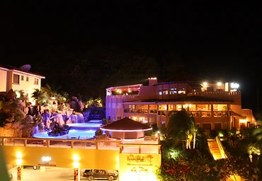 Pineapple Villas pool and building lit up at night