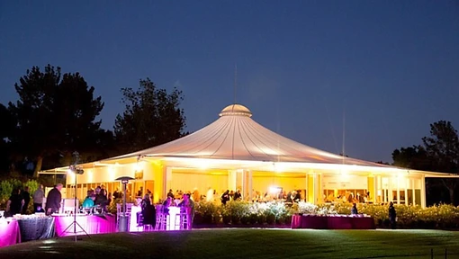 Glowing pavilion tent at twilight with magenta accent tables