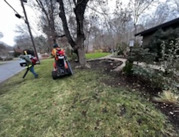 Crew member clearing leaves with a backpack blower