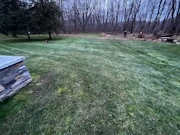Freshly striped lawn with a natural stone landscape wall