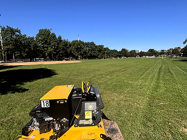 Commercial mower in a vast open green field